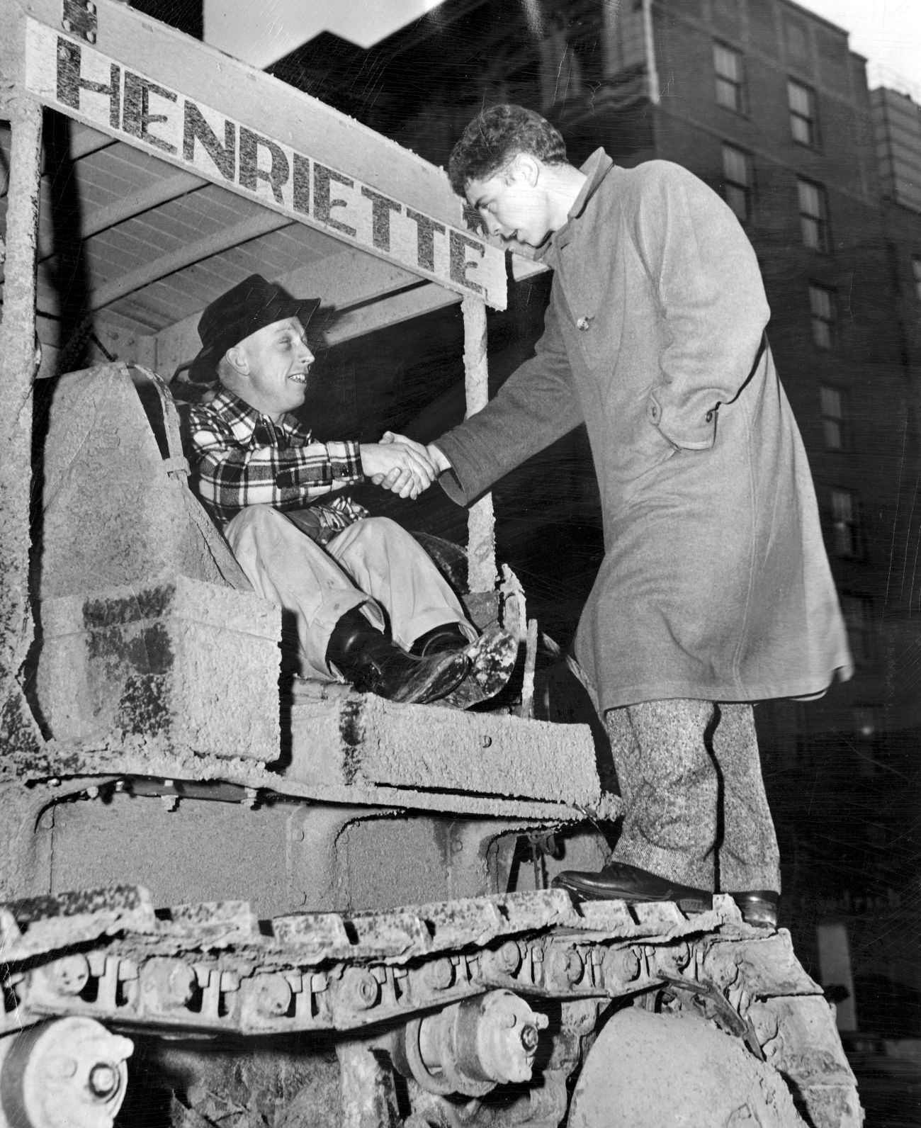 Howard Saferite, left, shakes hands with reporter John Koffend after Operation Snowbound. Saferite brought the 14 ton bulldozing tractor named Henriette from Kansas City to help with snow removal and Koffend was the reporter who followed Henriette's experiences in blizzard country. Published Feb. 20, 1949.